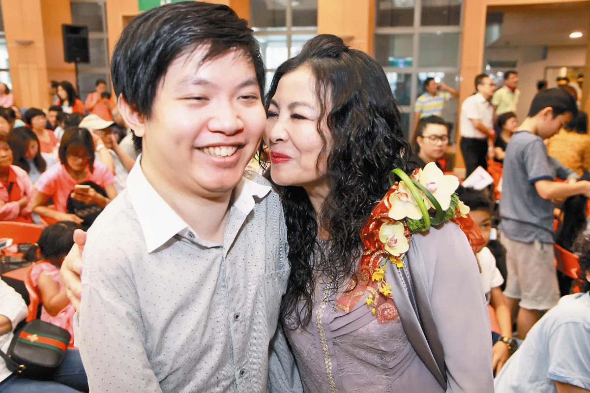 用腳寫下我愛您 媽愛不放棄 癱兒赴美攻碩