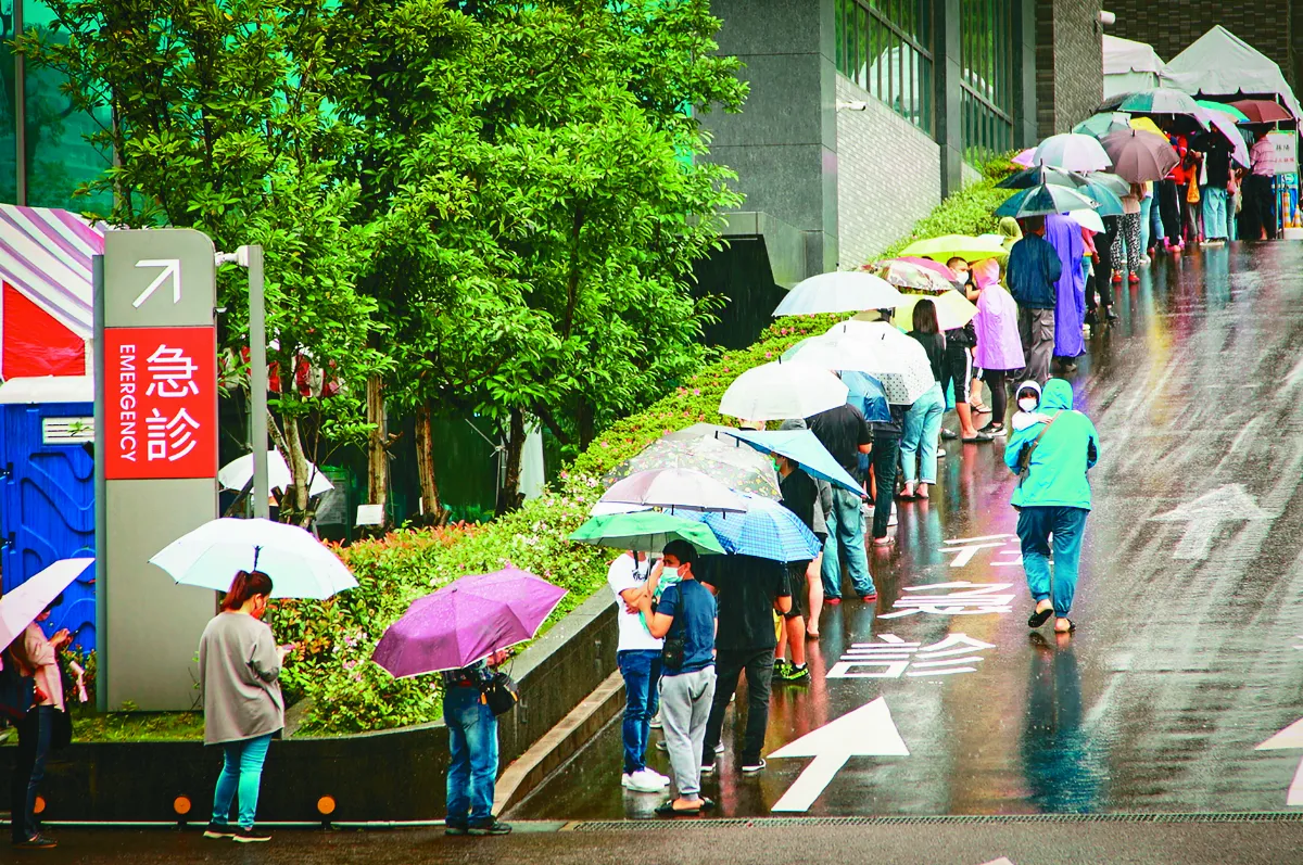疫情嚴峻 冒雨等待篩檢