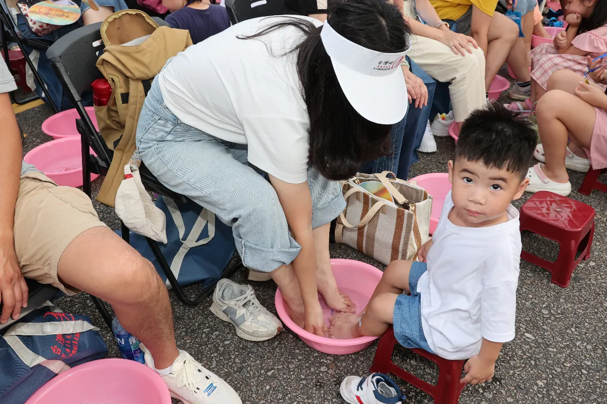 千人孝親洗腳報恩活動 小朋友跟著媽媽一同在烈日下泡腳